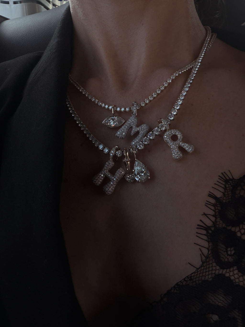 Diamond initial charms styled on tennis necklaces; necklaces and other charms sold separately